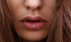 a close up of a woman's face with a nose piercing