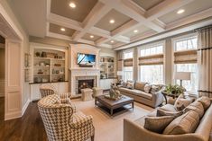 a living room with couches, chairs and a tv in it's center