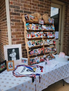 a table with pictures and other items on it in front of a brick building,