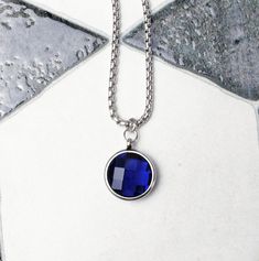 《《  FOR YOUR JOURNEY COLLECTION  》》 THE DETAILS The "FACETED SAPPHIRE COIN" Necklace is designed with an incredibly detailed Silver Stainless Steel Open Ring Bezel Pendant, with a luxurious lightweight Micro-Faceted Cushion Cut Sapphire Cubic Zirconia Stone, suspended from a Silver Stainless Steel Box Chain available in your choice of length! GEMSTONE BENEFITS SAPPHIRE CUBIC ZIRCONIA: Known as the Stone of "WISDOM & PROSPERITY", often worn for its abilities to stimulate concentration, while enha Multicolor Pearl Necklace, Blue Sapphire Pendant, Ring Bezel, Coin Pendant Necklace, Mens Chain Necklace, Garnet Pendant, Garnet Necklace, Sapphire Pendant, Bezel Pendant