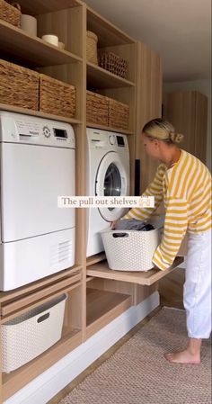 a woman is looking at the washer and dryer