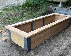 a large wooden box sitting on top of a dirt field