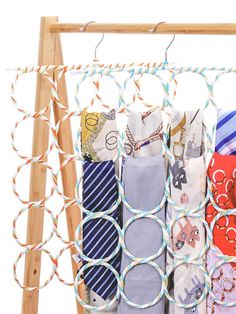 several ties are hanging on a wooden rack