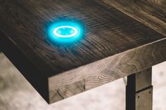 a wooden table with a blue light on it's side and some metal legs