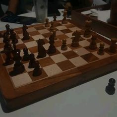 a wooden chess board with pieces on it