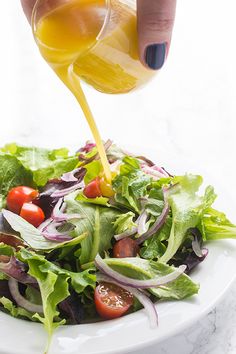 a salad with dressing being poured onto it