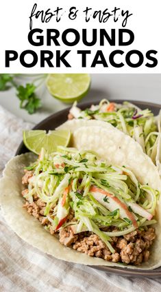 two pork tacos with cole slaw and lime on the side