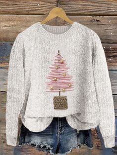 a white sweater with a pink christmas tree on the front and gold ornaments on the back