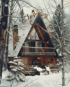 a cabin in the woods with snow on the ground