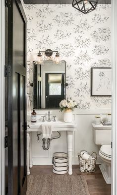 a bathroom with a sink, mirror and toilet in it's corner area next to a doorway