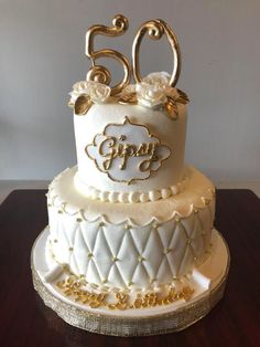 a white and gold 50th birthday cake on a table