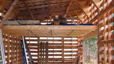 the inside of a wooden structure with wood slats on it and ladders hanging from the ceiling