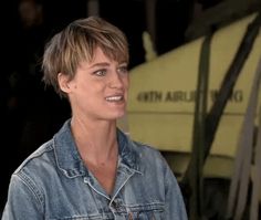 a woman with short hair wearing a jean jacket