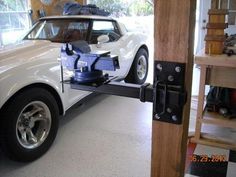 a car being towed by a tow truck in a garage with tools on the back