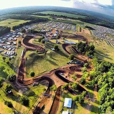 an aerial view of a dirt bike track in the middle of a field with cars parked on it