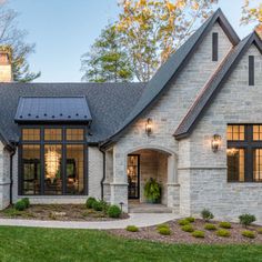 a large brick house with solar panels on it's roof and windows in the front