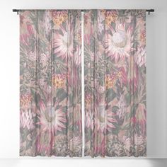 a window curtain with pink and green flowers on the outside, in front of a white wall