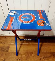 an orange and blue table with chicago bears decals on the top is sitting in front of a white wall