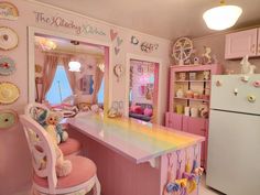 a pink kitchen with lots of toys and decor