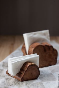 two small pieces of wood sitting on top of a wooden table covered in wax paper