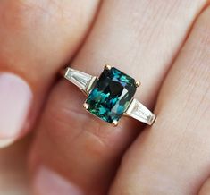 Dolores Radiant Teal Sapphire Ring with Baguette Diamonds – Capucinne Engagement Ring Baguette, Baguette Engagement Ring, Teal Sapphire, Baguette Diamond Rings, Alexandrite Engagement Ring, Sapphire Engagement Ring, Three Stone Engagement, Sapphire Diamond Ring, Three Stone Engagement Rings