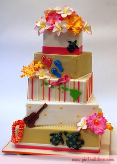 a three tiered cake with flowers and decorations on the top, sitting on a table