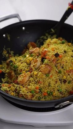 a pan filled with rice and vegetables on top of a stove