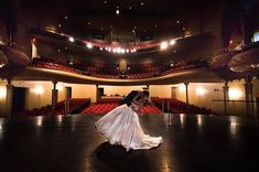 a woman in a white dress is dancing on the floor