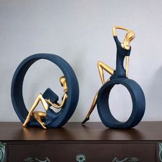 two sculptures sitting on top of a wooden table