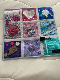 a close up of a quilt on a bed with buttons and other things in it