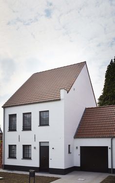 a large white house with two garages on each side