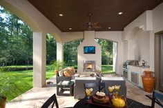 an outdoor living area with fireplace and television