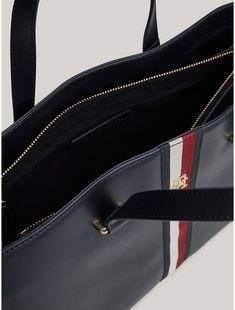 Tommy Hilfiger women's bag. Signature branding and gold-tone hardware set the tone of this sophisticated tote bag, complete with dual carry handles for comfortable toting. It also features side zips and an expandable lining to change its shape and add room to the main compartment.  Material: 100% Polyurethane. Business Shoulder Bag With Double Handle And Branded Hardware, Tommy Hilfiger Leather Shoulder Bag For Daily Use, Daily Use Double Handle Bag With Branded Hardware, Double Handle Bags With Gold-tone Hardware, Classic Tommy Hilfiger Everyday Bag, Business Tote Satchel With Branded Hardware, Business Tote Bag With Gold-tone Hardware, Business Tote Bags With Gold-tone Hardware, Tommy Hilfiger Bags With Zipper Closure For Everyday Use