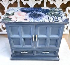 a blue cabinet with flowers painted on it