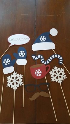 snowflakes, hats and mustaches are on sticks in front of a wooden table