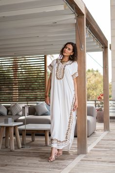 "An elegant Moroccan caftan with gold details will make you feel like African royalty. It's extremely elegant with a dash of classy hand embroidery in the front. Ideal for plus size women as well. Made of extremely soft fabric to make you feel free and beautiful at the same time.  This Kaftan is ideal to wear for any casual occasion. Whether taking a trip down the shopping lane, or home-based kitty parties, or about anything else, wearing this dress will make you feel classy and comfortable. Fab White Tunic Abaya For Summer, White Summer Tunic Abaya, White Maxi Dress For Eid Vacation, Traditional White Thobe For Beach, Traditional White Thobe For Vacation, White Kaftan For Eid Vacation, Gold Kaftan For Summer Vacation, White Beach Dress For Eid, White Maxi Dress For Beach Eid Festival