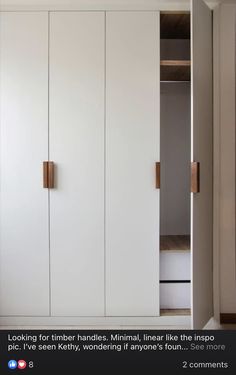 a white closet with wooden handles and doors