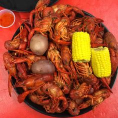 a plate full of cooked crawfish and corn on the cob