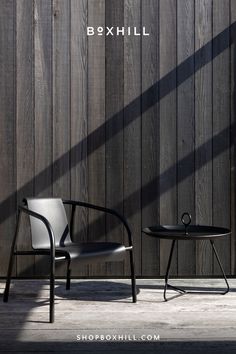 A black metal outdoor lounge chair and a black round metal outdoor tray table placed on a wooden deck against wooden wall Natural Place, Elegant Garden, Garden Chair, Table Haute