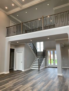 an empty living room with stairs leading up to the second floor and another open door