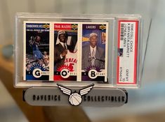 three different basketball cards are on display in a case