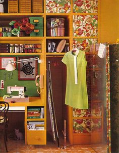 a yellow bookcase filled with lots of books next to a desk and chair in a room