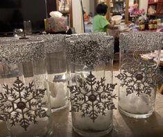 three glass vases with snow flakes in them