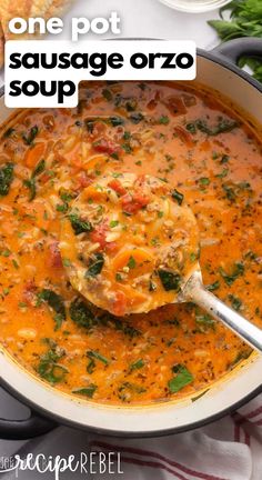 one pot sausage orzo soup in a white bowl with a ladle scooping out