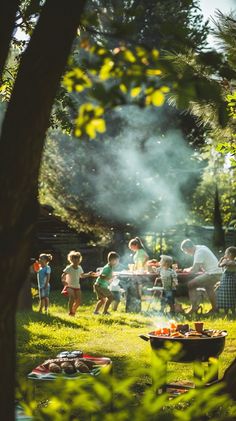 a group of people standing around a grill on top of a grass covered field next to trees