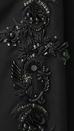 an embroidered black dress with beads and flowers