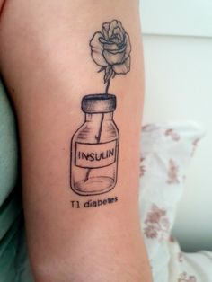 a small tattoo with a rose in a jar on the left side of the arm