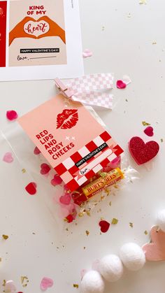 valentine's day greeting card with candy and confetti on the table next to it