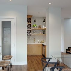 an open kitchen and living room with stairs leading up to the second floor, along with a dining area