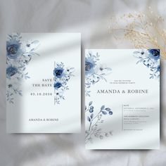 two wedding cards with blue flowers and greenery on the front, one in white